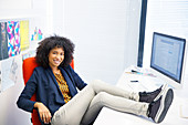 Businesswoman with feet up on desk