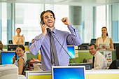 Businessman cheering in office