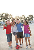 Children playing with soccer ball in sand