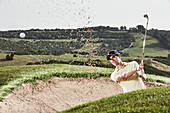 Man swinging from sand trap