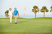 Senior couple walking on golf course