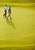 Senior men walking on golf course