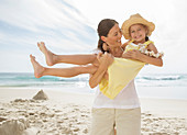 Mother holding daughter on beach