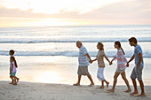 Multi-generation family walking on beach