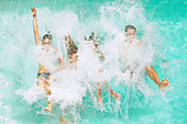 Family jumping into swimming pool