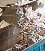 Bucket dumping recycled bundles into bin