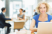Businesswoman using laptop in cafe