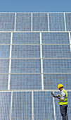 Worker examining solar panels