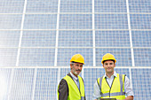Workers standing by solar panel