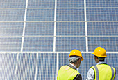 Workers examining solar panels
