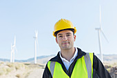 Worker standing by wind turbines