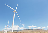 Wind turbines spinning in rural landscape