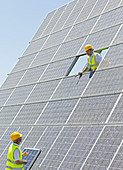 Workers examining solar panels