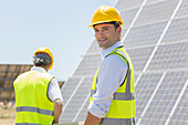 Workers walking by solar panels
