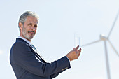 Businessman by wind turbine