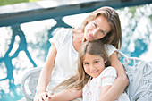 Mother and daughter relaxing at poolside