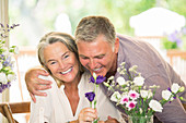 Senior couple smelling flowers