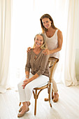 Mother and daughter smiling at window