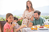 Family eating together at patio table
