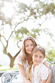 Mother and daughter hugging outdoors