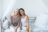 Mother and daughter smiling on daybed