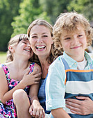 Mother and children smiling outdoors