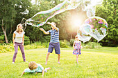 Family playing with large bubbles