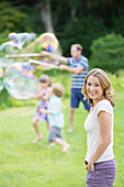 Family playing with bubbles in backyard