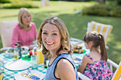 Family eating at table in backyard