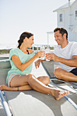 Couple toasting glasses on lounge chairs