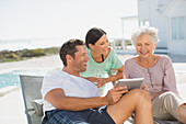 Family using digital tablet at poolside