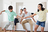 Parents watching daughter and son dancing