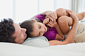 Father hugging daughter on bed