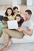 Family using laptop on sofa