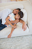 Father and son napping on sofa