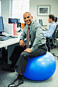 Businessman sitting on fitness ball