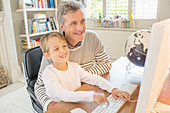 Father and son using computer together