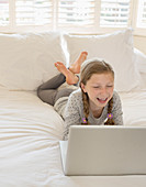 Girl using laptop on bed