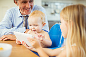 Father and children using digital tablet