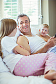 Father and children relaxing on bed