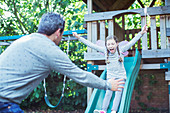 Father catching daughter on slide