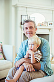 Father holding son in living room