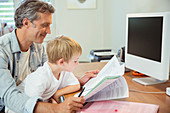 Father and son working in home office