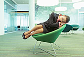 Businesswoman napping in office chair