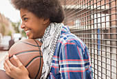 Woman holding basketball outdoors