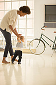 Mother helping baby boy walk