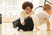 Mother watching baby boy crawl