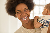 Laughing mother holding baby boy