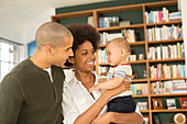 Couple holding baby in living room