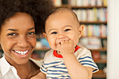 Mother holding baby boy in living room